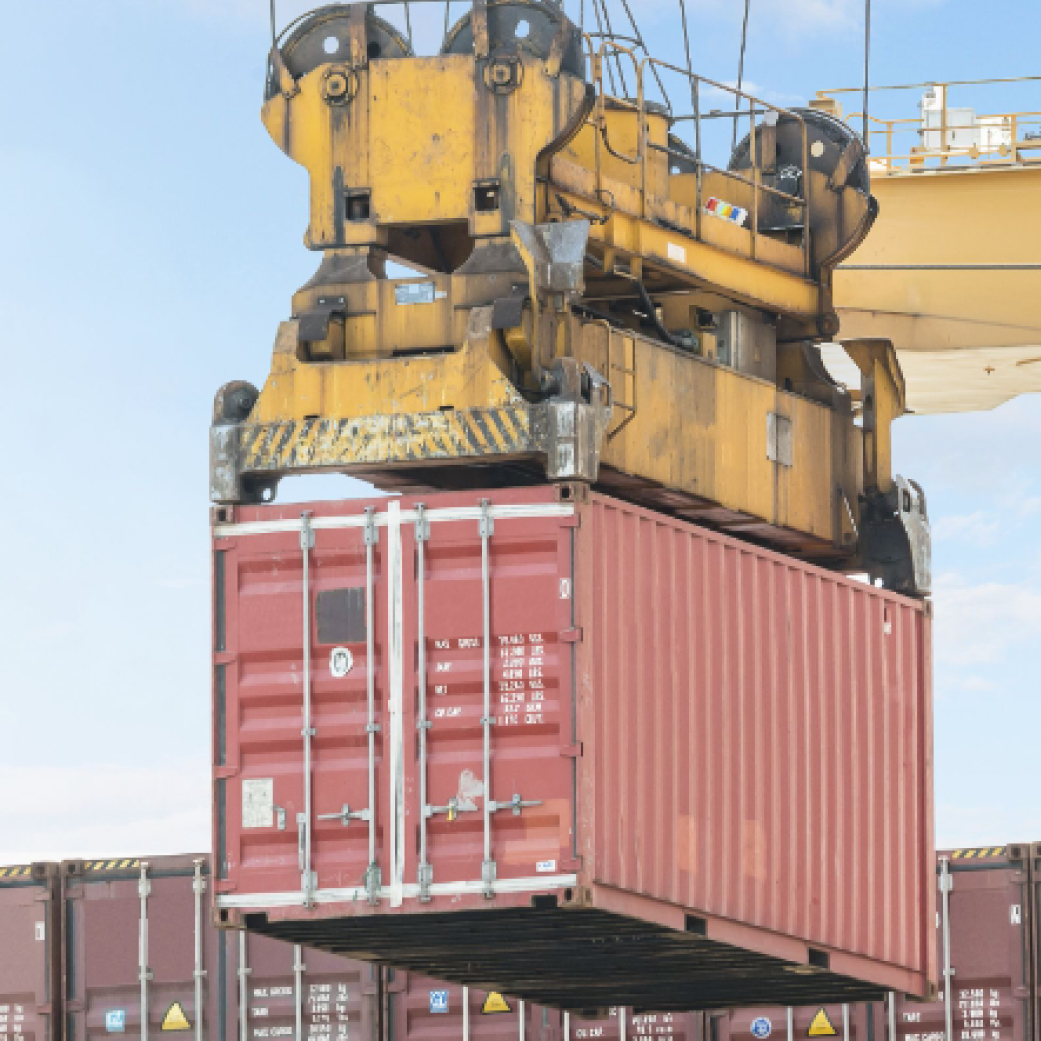 A crane hoisting a container from a dock, showcasing efficient cargo handling at a port.